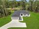 Aerial view of a well-maintained property with lush green grass, a long driveway, and a spacious two-car garage at 33 Peterlee Ct, Kissimmee, FL 34758