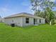 Spacious backyard featuring lush green grass, a patio, and an air conditioning unit at 33 Peterlee Ct, Kissimmee, FL 34758