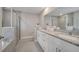 Spacious bathroom with double vanity, granite counters, a glass-enclosed shower and soaking tub at 33 Peterlee Ct, Kissimmee, FL 34758