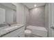 Bathroom with a tub, tiled walls, a white sink with a granite countertop, and a large mirror at 33 Peterlee Ct, Kissimmee, FL 34758