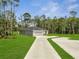 Landscaped property featuring a long driveway and a modern home design surrounded by lush greenery at 33 Peterlee Ct, Kissimmee, FL 34758