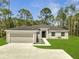Charming single-story home featuring a well-manicured lawn, two car garage, and welcoming entrance at 33 Peterlee Ct, Kissimmee, FL 34758