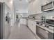 Modern kitchen featuring stainless steel appliances, white cabinetry, and granite countertops at 33 Peterlee Ct, Kissimmee, FL 34758