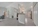 Open-concept living space with gray tile flooring and neutral color palette, flowing into modern kitchen at 33 Peterlee Ct, Kissimmee, FL 34758