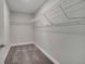 Carpeted walk-in closet with white wire shelving offers convenient storage solutions at 33 Peterlee Ct, Kissimmee, FL 34758