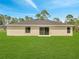 Rear exterior of home with a well-maintained lawn and sliding glass door at 35 Peterlee Ct, Kissimmee, FL 34758