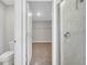 Bright bathroom with glass shower, toilet and an open door view into carpeted walk-in closet at 35 Peterlee Ct, Kissimmee, FL 34758
