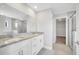 Bright bathroom featuring a double sink vanity with granite countertop, and a glass-enclosed shower at 35 Peterlee Ct, Kissimmee, FL 34758