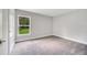 Bright bedroom with large window overlooking green space, features carpeted flooring and neutral paint at 35 Peterlee Ct, Kissimmee, FL 34758