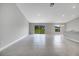 Bright, airy living room featuring sliding glass doors, gray ceramic flooring, and modern light fixture at 35 Peterlee Ct, Kissimmee, FL 34758