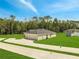 Scenic view of a single-Gathering home's backyard featuring green lawn, mature trees, and a spacious driveway at 35 Peterlee Ct, Kissimmee, FL 34758