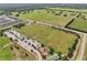 An aerial view showcasing a park, ball field, playground and community with lush green spaces and a neighborhood nearby at 355 Churchill Ct, Kissimmee, FL 34759