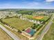 Aerial community view showcasing a ball field, playground, large athletic field, and a nearby basketball court at 355 Churchill Ct, Kissimmee, FL 34759