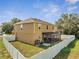 Two-story home's backyard featuring white vinyl fencing, a screened-in patio, and a lawn at 355 Churchill Ct, Kissimmee, FL 34759