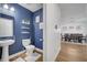 Stylish half bath with blue accent wall, modern fixtures, and wood-look floors at 355 Churchill Ct, Kissimmee, FL 34759