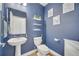 Stylish half bath with blue accent wall, modern fixtures, and wood-look floors at 355 Churchill Ct, Kissimmee, FL 34759