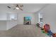 Bright, carpeted bonus room offering ample space, large windows, a ceiling fan, and a entertainment center at 355 Churchill Ct, Kissimmee, FL 34759