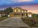 Charming two-story home with a spacious driveway and colorful sunset backdrop at 355 Churchill Ct, Kissimmee, FL 34759