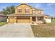 Attractive two-story home with a red door, three-car garage, and verdant lawn at 355 Churchill Ct, Kissimmee, FL 34759