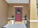 Inviting front door adorned with a wreath, flanked by elegant potted plants at 355 Churchill Ct, Kissimmee, FL 34759