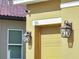Side exterior view with security camera, address number, and coach lights at 355 Churchill Ct, Kissimmee, FL 34759