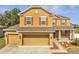 Close-up of a well-maintained home with a large three-car garage and manicured lawn at 355 Churchill Ct, Kissimmee, FL 34759