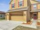 Home exterior featuring a spacious three-car garage, red door, and stylish accents at 355 Churchill Ct, Kissimmee, FL 34759
