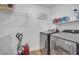 Laundry room with washer, dryer, and white shelving with laundry supplies for all your cleaning needs at 355 Churchill Ct, Kissimmee, FL 34759