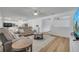 Bright living room with contemporary furniture and wood flooring adjoining a modern white kitchen at 355 Churchill Ct, Kissimmee, FL 34759
