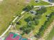Aerial view featuring a park with walking paths, picnic areas, and lush landscaping, next to a basketball court at 355 Churchill Ct, Kissimmee, FL 34759