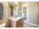 Bright bathroom features a tile floor, wood vanity and access to the back patio at 3856 Shoreside Dr, Kissimmee, FL 34746