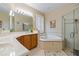 Bright bathroom featuring a soaking tub, glass enclosed shower, and double vanity at 3856 Shoreside Dr, Kissimmee, FL 34746