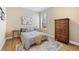 Cozy bedroom with a comfortable bed, wood flooring, natural light, and a wooden dresser at 3856 Shoreside Dr, Kissimmee, FL 34746