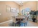 Charming dining room featuring a round wooden table, upholstered chairs, and a chandelier with a window view at 3856 Shoreside Dr, Kissimmee, FL 34746