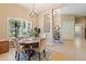 Lovely dining room featuring a round table, four chairs, stylish chandelier, and a large window with plantation shutters at 3856 Shoreside Dr, Kissimmee, FL 34746