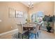 Lovely dining room featuring a round table, four chairs, stylish chandelier, and a large window with plantation shutters at 3856 Shoreside Dr, Kissimmee, FL 34746