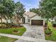 Beautiful single-story home with mature trees, manicured lawn, a brick driveway, and a two-car garage at 3856 Shoreside Dr, Kissimmee, FL 34746