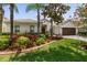 Well-maintained single-story home with tropical landscaping, a paver driveway, and a two-car garage at 3856 Shoreside Dr, Kissimmee, FL 34746