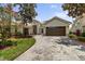 Inviting single-story home with a paver driveway, manicured landscaping, and a two-car garage at 3856 Shoreside Dr, Kissimmee, FL 34746
