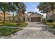 Attractive single-story home featuring lush landscaping, a paver driveway, and a two-car garage at 3856 Shoreside Dr, Kissimmee, FL 34746