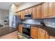 Well-equipped kitchen with stainless steel appliances, wood cabinets, and sleek countertops with tile backsplash at 3856 Shoreside Dr, Kissimmee, FL 34746