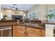 Kitchen area highlighting granite countertops, wood cabinetry, stainless steel appliances, and open design to living area at 3856 Shoreside Dr, Kissimmee, FL 34746