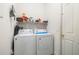 Practical laundry room with washer, dryer, storage shelves, and a neatly arranged selection of cleaning supplies at 3856 Shoreside Dr, Kissimmee, FL 34746