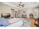 Bright main bedroom featuring a ceiling fan, gray toned furniture and an en-suite bathroom at 3856 Shoreside Dr, Kissimmee, FL 34746