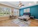 Comfortable main bedroom featuring a decorative ceiling fan, lots of light from the window, and an accent wall at 3856 Shoreside Dr, Kissimmee, FL 34746