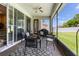 Relaxing screened patio with stylish outdoor furniture and a ceiling fan overlooking a well-manicured lawn at 3856 Shoreside Dr, Kissimmee, FL 34746
