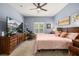 Spacious bedroom features a large bed, ceiling fan, desk, and large TV for comfortable living at 4056 Ashton Club Dr, Lake Wales, FL 33859