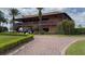 Elegant clubhouse featuring a beautiful brick drive, lush landscaping, and golf carts at 4056 Ashton Club Dr, Lake Wales, FL 33859