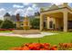 Attractive clubhouse with tiered fountain, colorful flowers, and manicured lawn at 4056 Ashton Club Dr, Lake Wales, FL 33859