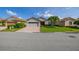 Lovely single-story home with a brick driveway, two-car garage, and a well-maintained lawn with mature trees at 4056 Ashton Club Dr, Lake Wales, FL 33859